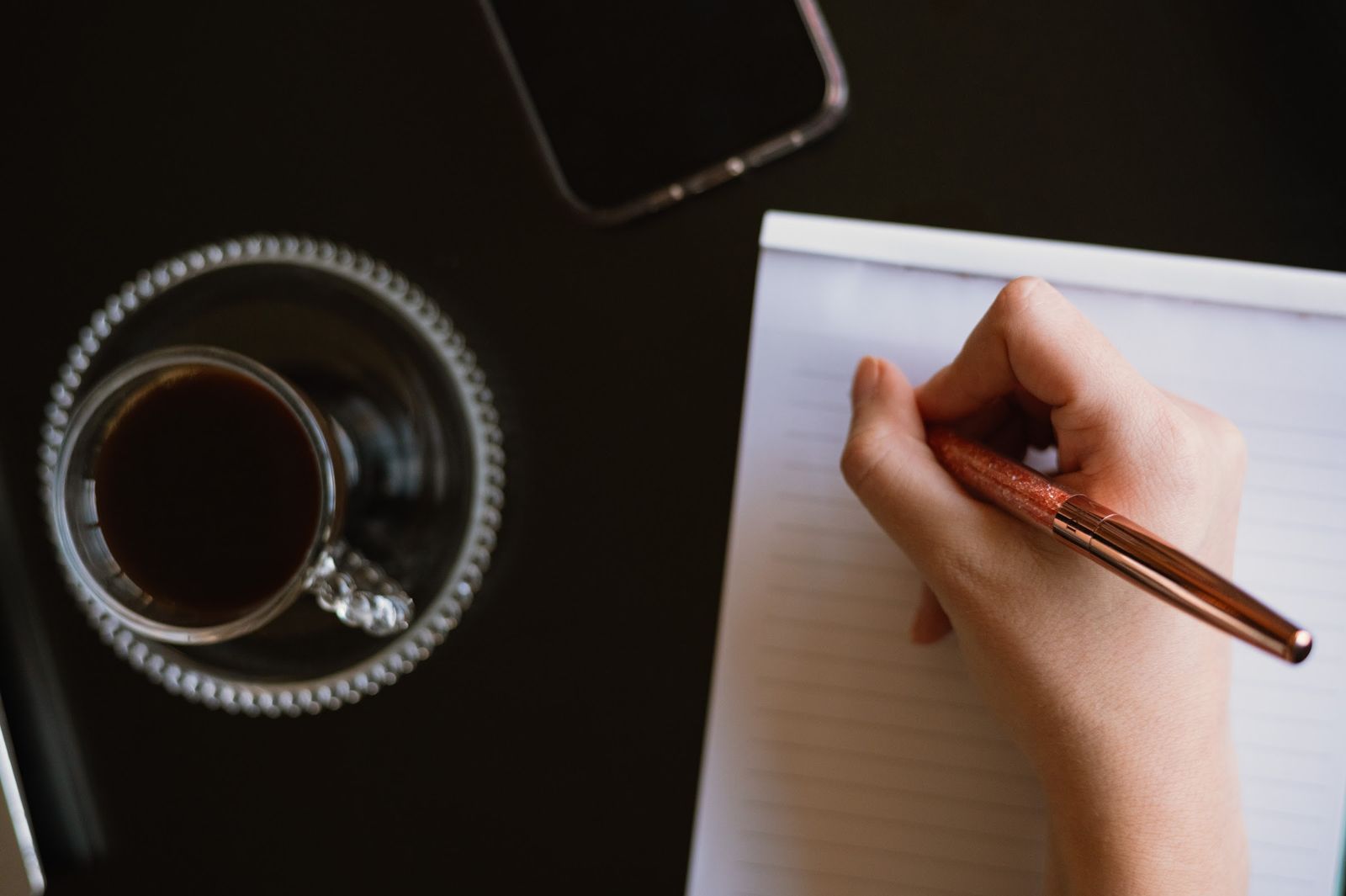 Anotações e café sobre a mesa de trabalho
